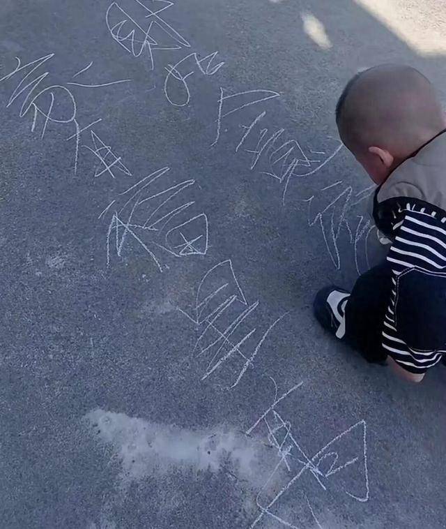 蘇州2歲半寶寶寫字看呆網友，拿石筆在地上寫字乾淨利落，媽媽：家中沒人擅長書法